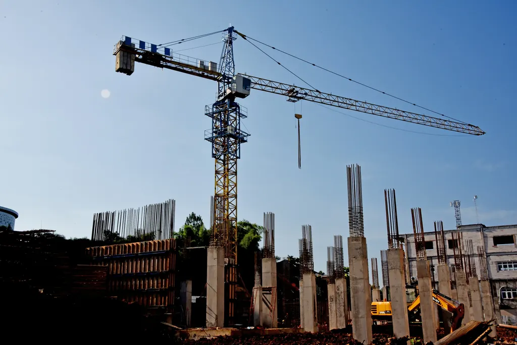 Tower crane above a construction site with reinforced concrete columns