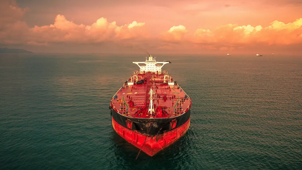 Crude oil tanker at sea under a glowing sunset sky