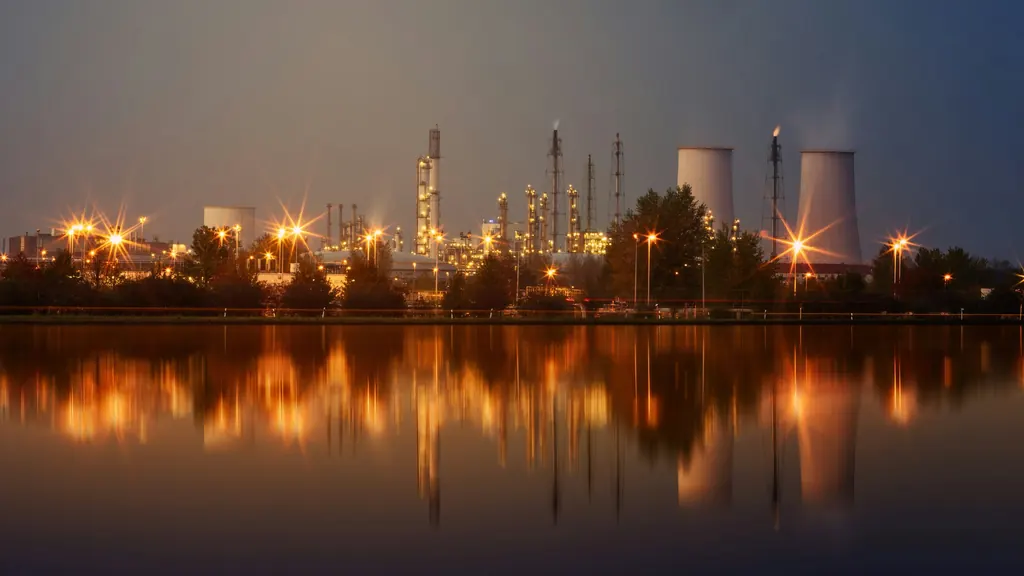 Industrial skyline lit at night and reflected in still water