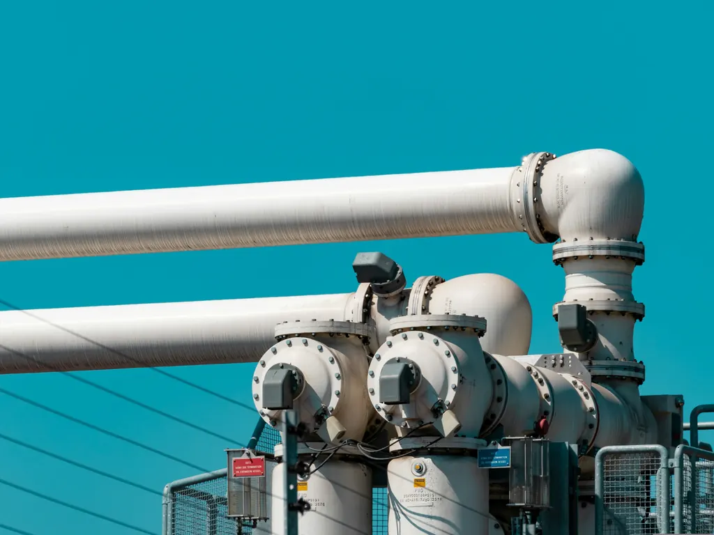 Insulated process pipework and valves on a steel structure against a blue sky