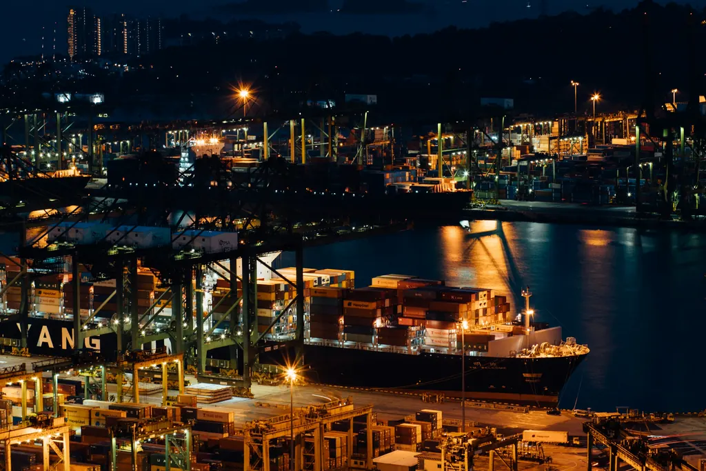 Container and tanker port at night with vessels alongside