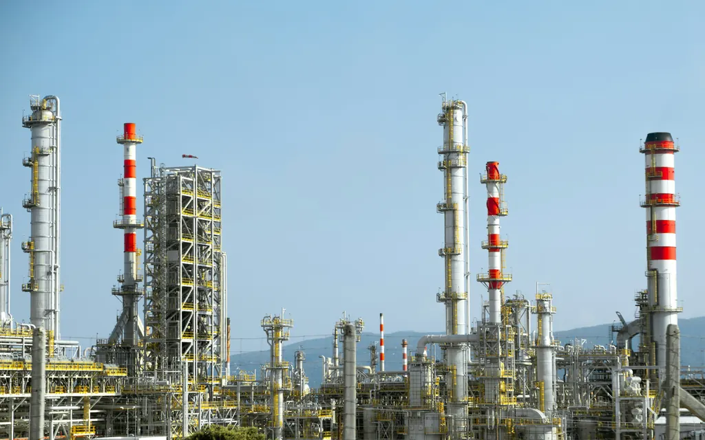 Red and white process towers and pipework at an industrial plant