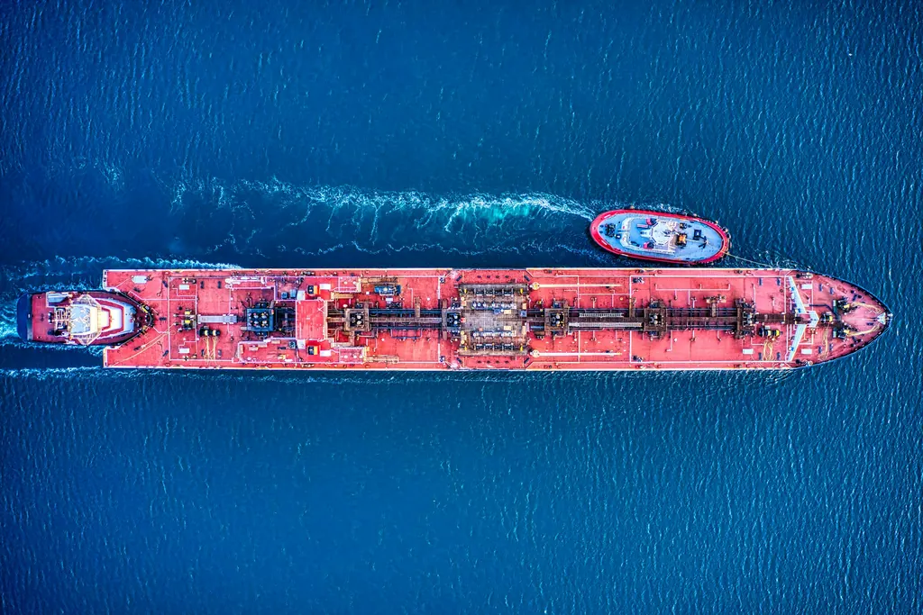 Aerial view of a tanker at sea with a tug alongside